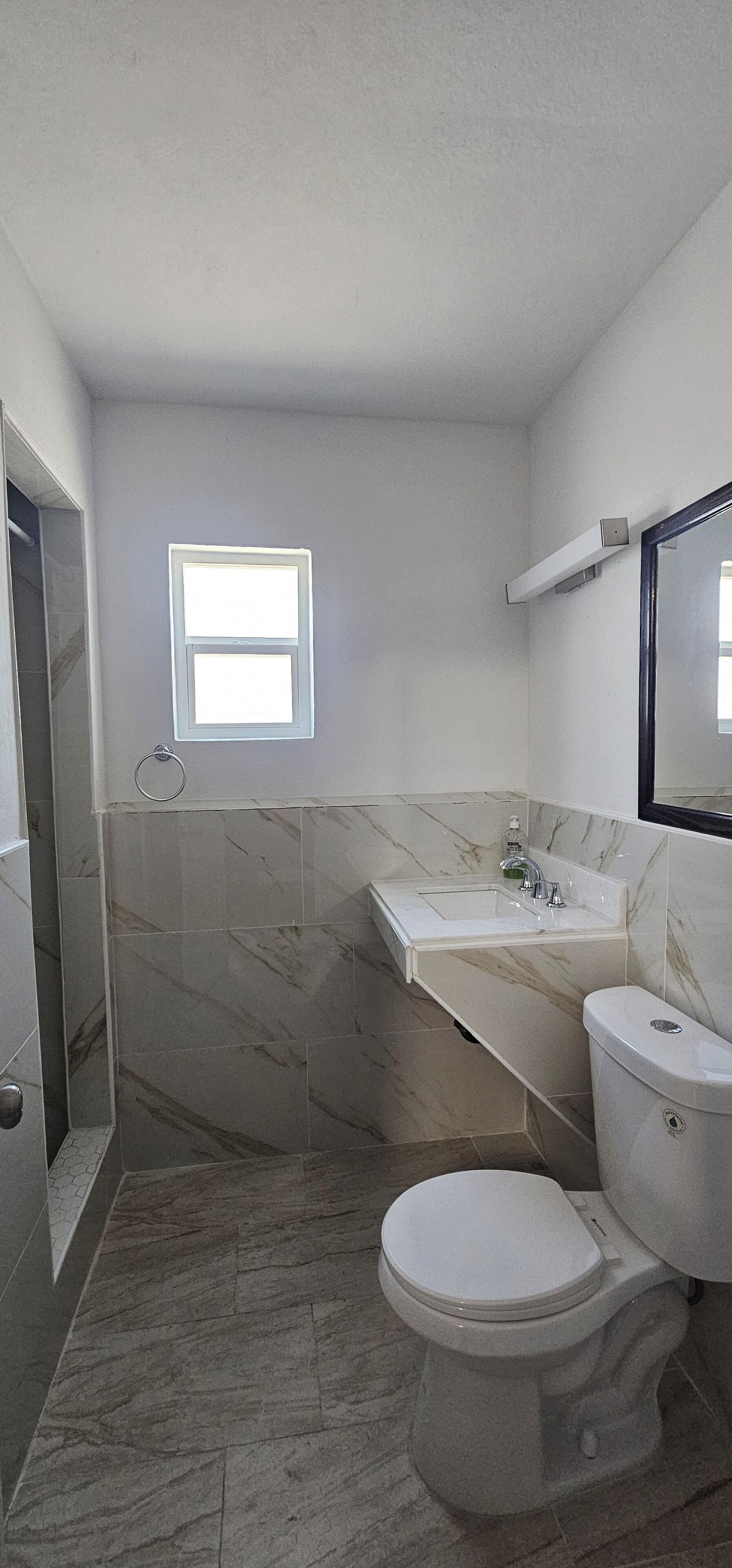 A bathroom with a toilet, sink, and shower area.