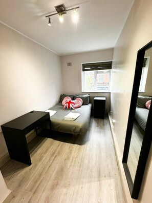 A compact bedroom with a bed, bedside table, and a window. - London Bunk & Bed Loft (London)