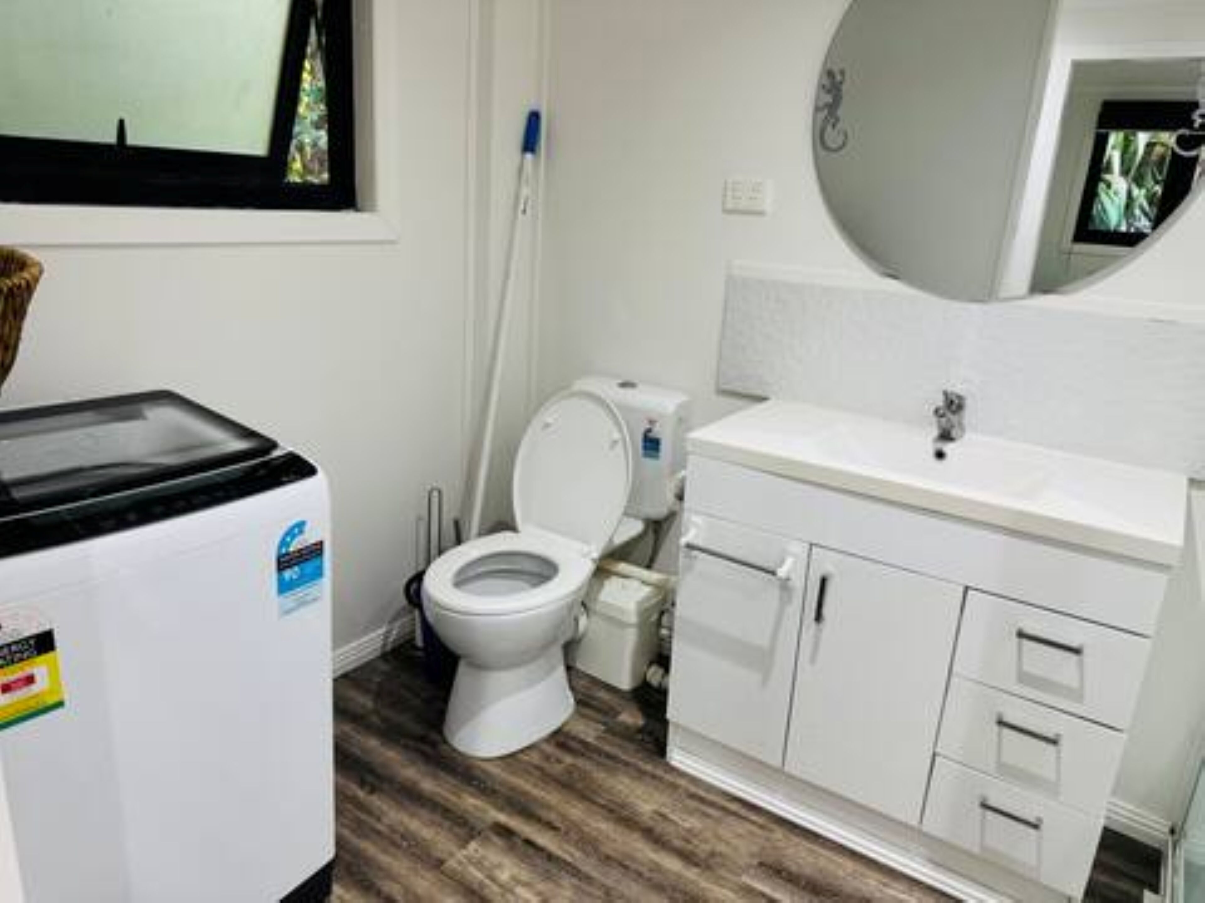 A bathroom with a toilet, sink, and a trash bin.