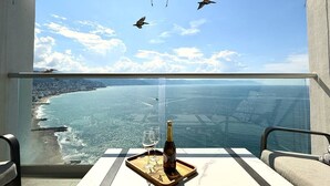 A balcony with a clear view of the sea, a bottle of champagne, and two glasses on a tray. - Oceanview 1BR w/ Breakfast | Rooftop Pool & Gym (Puerto Vallarta)