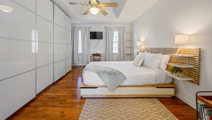 A bedroom with a bed, bedside tables, a ceiling fan, a TV, and a bookshelf. - 1223 Settlebench Ln NW Kennesaw (Kennesaw)