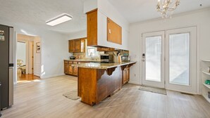 A spacious kitchen with wooden cabinets, a large island, a microwave, and a toaster. - 1223 Settlebench Ln NW Kennesaw (Kennesaw)