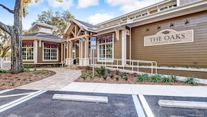 A building labeled "The Oaks Community Center" with a parking lot and a covered entrance. - 2063 Beachwood Lovely 2 Bedroom, 2 Bath Beach Wood Villa is Located in Amelia Island Plantation Resort (Fernandina Beach)