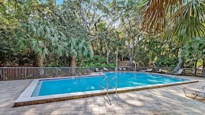 A rectangular swimming pool with a tiled deck, surrounded by lush greenery and trees. - 2063 Beachwood Lovely 2 Bedroom, 2 Bath Beach Wood Villa is Located in Amelia Island Plantation Resort (Fernandina Beach)