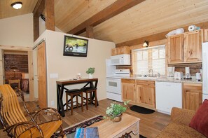 A wooden interior with a kitchen, dining area, and seating. - True Grit Adventure (Island Park)