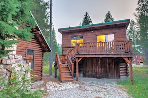 A log cabin with a wooden deck and stairs leading to a balcony. - Double Loop (Island Park)