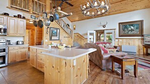 Une cuisine spacieuse dotée de meubles en bois, d’un îlot central et d’un coin repas comprenant un canapé et une table.