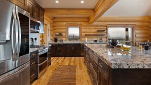 Eine moderne Küche mit Holzschränken, Edelstahlgeräten und einer Marmorarbeitsplatte.
