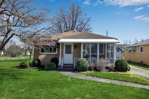 A single-story house with a front porch, a garage, and a well-maintained lawn. - Cozy home in Buffalo near Airport with, Air Cond, 3King Beds, Wi-Fi&Free Parking (Buffalo)