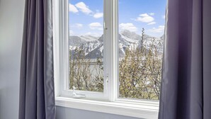 Una habitación con ventana que da a un paisaje montañoso.