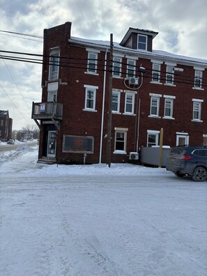 A two-story brick building with a sign for 'The Rustic Blend Cafe' and a visible outdoor area with snow. - Modern Mountain Retreat Apt-3-3| High-End Finishes| Easy Highway Access (Windber)