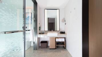 A modern bathroom with a glass shower enclosure, a white sink, and a mirror above it.
