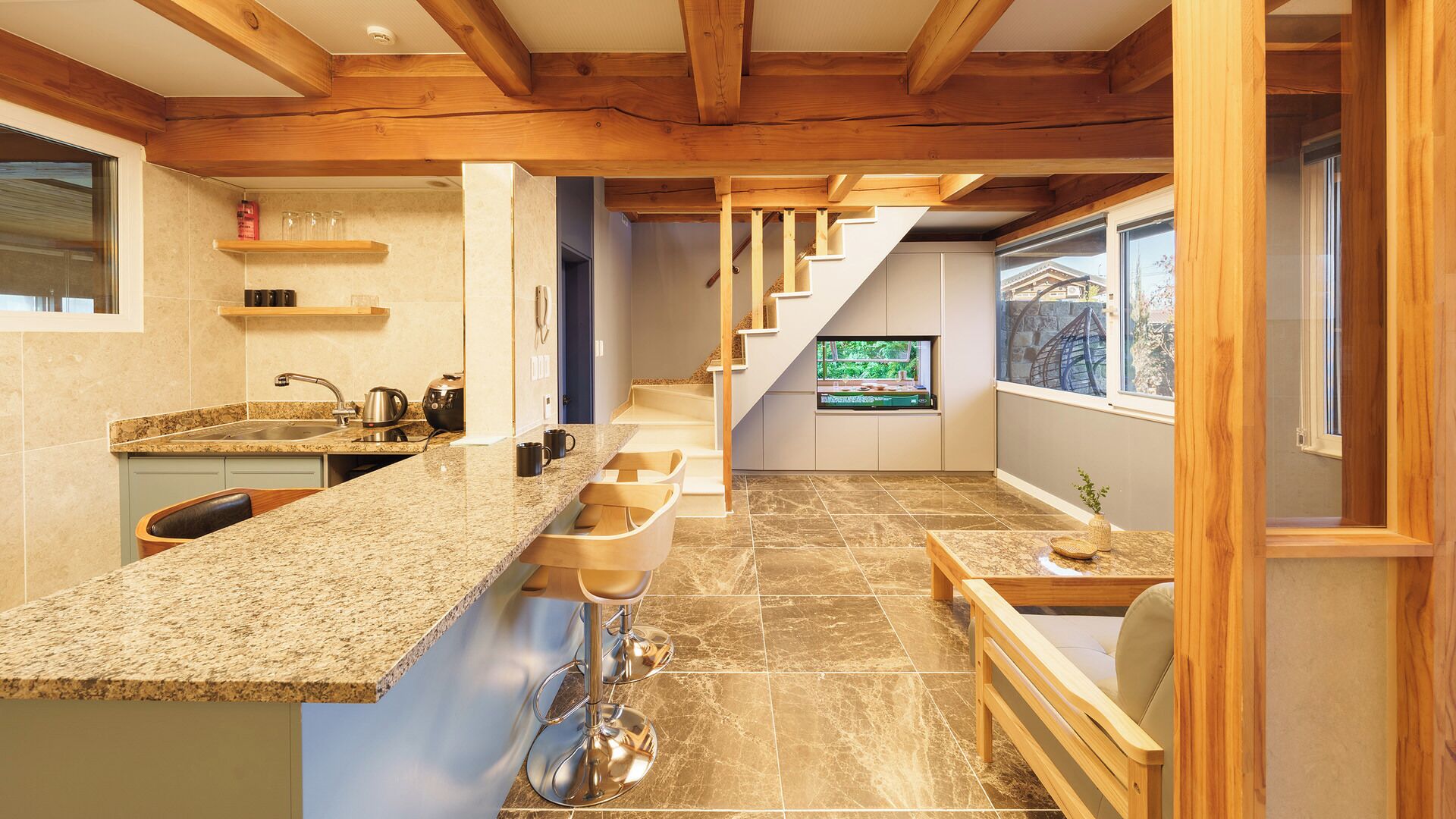 A modern kitchen with granite countertops, a built-in oven, and a stainless steel sink.
