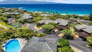 Et resort med flere bygninger, en swimmingpool og udsigt over havet.