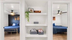 A room with two beds, a white shelving unit with folded towels, and ceiling fans. - New! Blue&pink Pool Centra PHX (Phoenix)