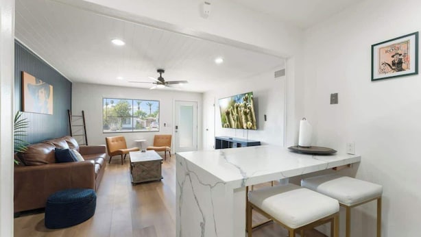 A modern kitchen with a marble countertop, a ceiling fan, and a large window. - New! Blue&pink Pool Centra PHX (Phoenix)