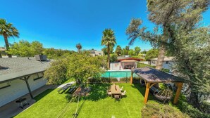 A backyard with a wooden pergola, a dining table, and a barbecue grill. - New! Blue&pink Pool Centra PHX (Phoenix)