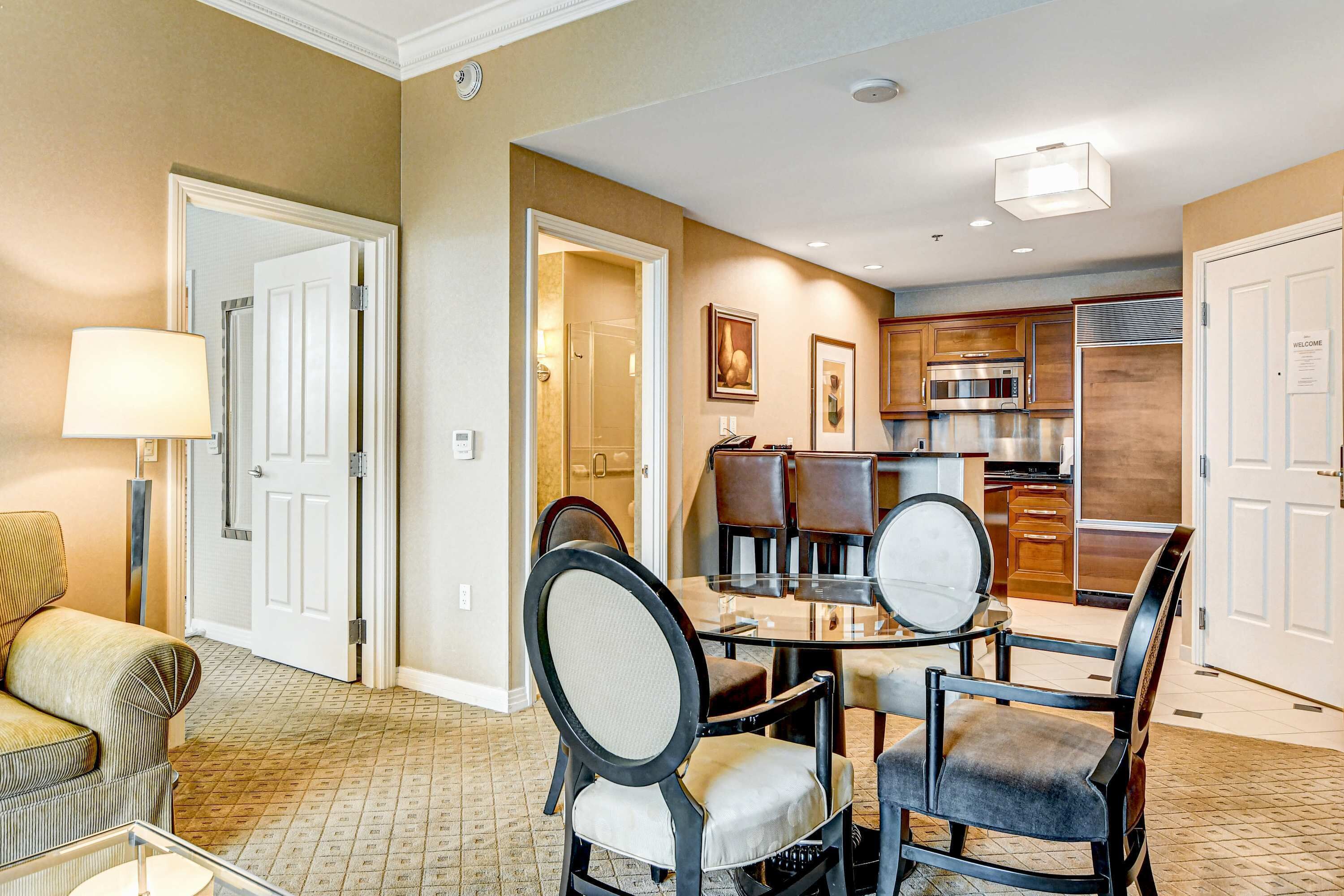 A hotel room with a dining area, a kitchen, and a living area.