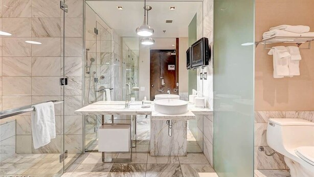 A modern bathroom with a glass-enclosed shower, a double sink vanity, and a toilet. - Beautiful Mountain-views Studio at the Palms 1107 (Las Vegas)