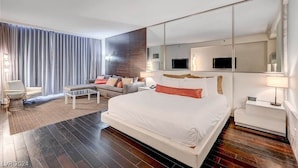 A modern hotel room with a large bed, a sofa, a coffee table, a TV, and a mirror. - Beautiful Mountain-views Studio at the Palms 1107 (Las Vegas)