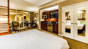 A hotel room with a bed, a desk, a chair, a kitchenette, and a bathroom. - Free Valet Parking MGM Studio 1911 (Las Vegas)