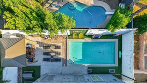 Vista aerea di una proprietà residenziale con piscina, patio coperto e piccolo giardino.