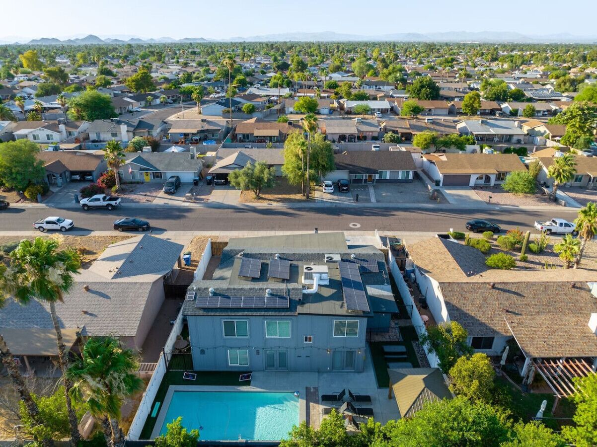 Zona residencial con casas, piscina y paneles solares en los tejados.