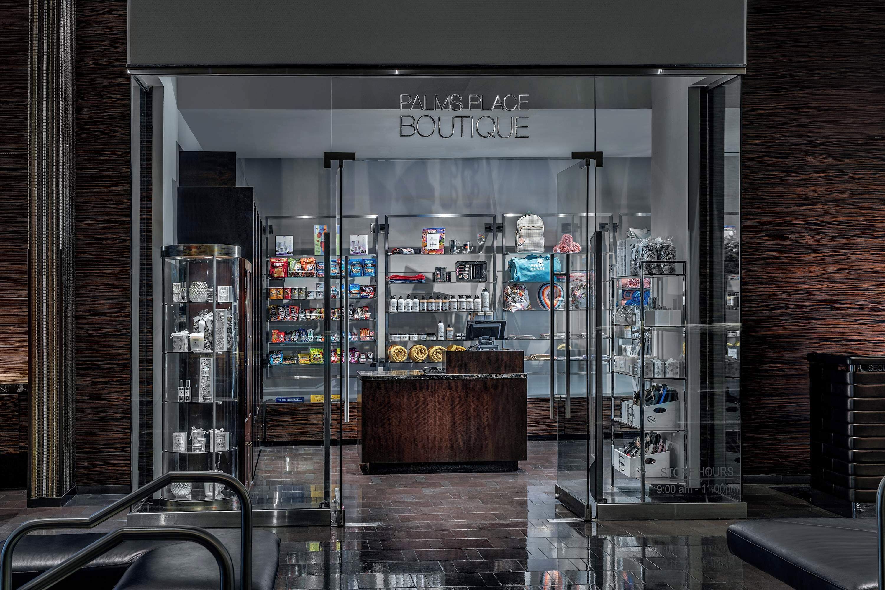 A boutique with a glass storefront, a reception desk, and shelves stocked with various items.