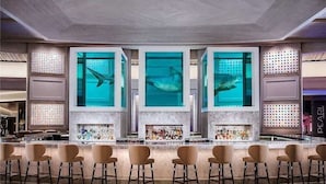 A bar area with multiple seating arrangements and a large aquarium display. - Luxurious Studio Balcony Access 26319 (Las Vegas)