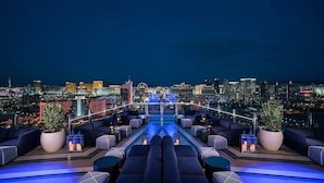 A rooftop lounge with a city view, featuring sofas, potted plants, and a pool. - Luxurious Studio Balcony Access 26319 (Las Vegas)