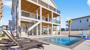Un edificio de varios pisos con piscina, zona de estar al aire libre y una escalera.