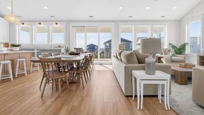 Un salón amplio con un gran ventanal, una mesa de comedor y un sofá.