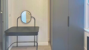 A room with a desk, a mirror, and a wardrobe. - Golders Green Cozy City Studio in London (London)