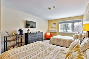A bedroom with two beds, a TV, a dresser, a chair, and a window with a view. - Hotel Style Condo Promising a Comfortable and Convenient Retreat Right in the Heart of Vermont ski Country (Killington)