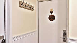 Una porta con una targa, una serratura a combinazione e un pannello appendiabiti a parete.