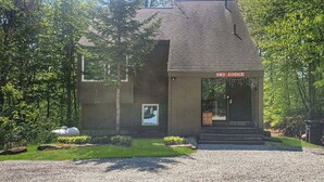 A lodge with a wooden exterior, a gravel driveway, and a sign reading 'Ski Lodge'. - Great Escape Ski Lodge (Killington)