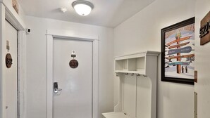 Ένας διάδρομος με μια λευκή πόρτα με  τον αριθμό 523, μια κρεμάστρα για παλτό και μια κορνιζαρισμένη πινακίδα με πληροφορίες για τις χιονοδρομικές περιοχές του Βερμόντ.