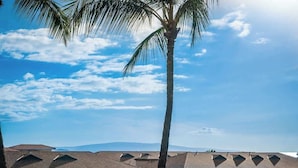 A hotel with multiple floors, each with a balcony. The building has a symmetrical roofline with triangular gables. - Beach Retreat Walk to Surf & Dining (Kihei)