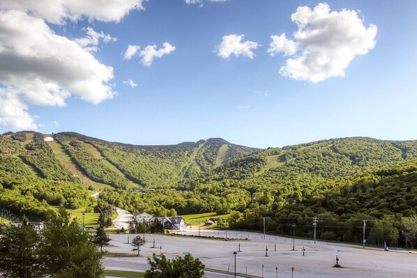Un parking offrant une vue sur un paysage montagneux et un bâtiment doté d’un toit en pente.