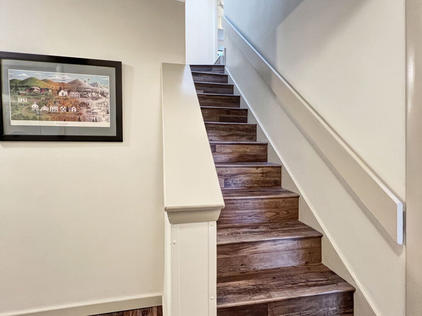 A staircase with wooden steps and a white handrail.