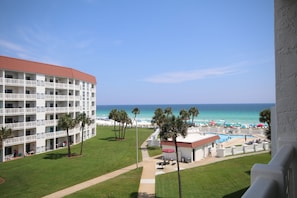 Ein Hotel mit Poolbereich, Palmen und Blick auf Strand und Meer.