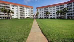 A modern hotel with a central pathway leading to a building with multiple floors and balconies. - 555 El Matador (Fort Walton Beach)