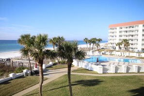 Et hotel med pool, palmer og havudsigt.