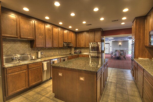 A kitchen with wooden cabinets, stainless steel appliances, and a granite countertop. - 362 El Matador (Fort Walton Beach)