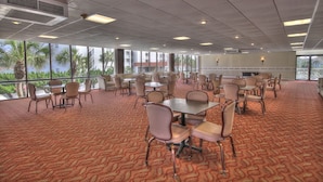 A conference room with tables and chairs, large windows, and a patterned carpet. - 152 El Matador (Fort Walton Beach)