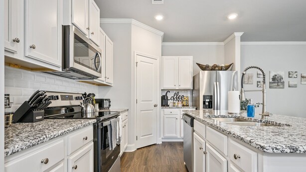 A modern kitchen with white cabinetry, a stainless steel refrigerator, a built-in oven, and a granite countertop. - 2059 Pinnacle Walk Drive, Norcross (Norcross)