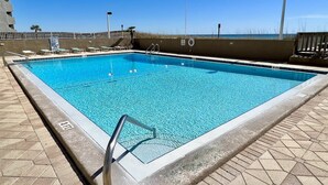 Una piscina rectangular con agua azul cristalina, rodeada por un solárium empinado.