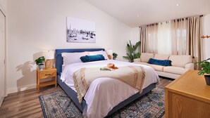 A modern bedroom with a bed, bedside tables, a sofa, and a large window with curtains. - 152-6 S Pacific Fantastic Ocean View (Oceanside)