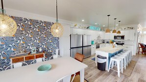 A modern kitchen with white cabinets, a large island, and a patterned backsplash. - Bermuda Breeze - A (North Myrtle Beach)