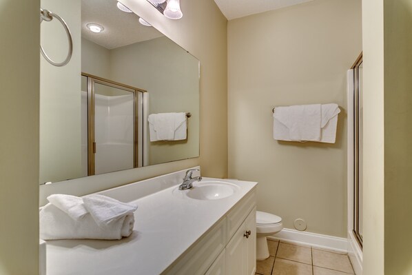 Une salle de bain avec un lavabo, un miroir et des toilettes.